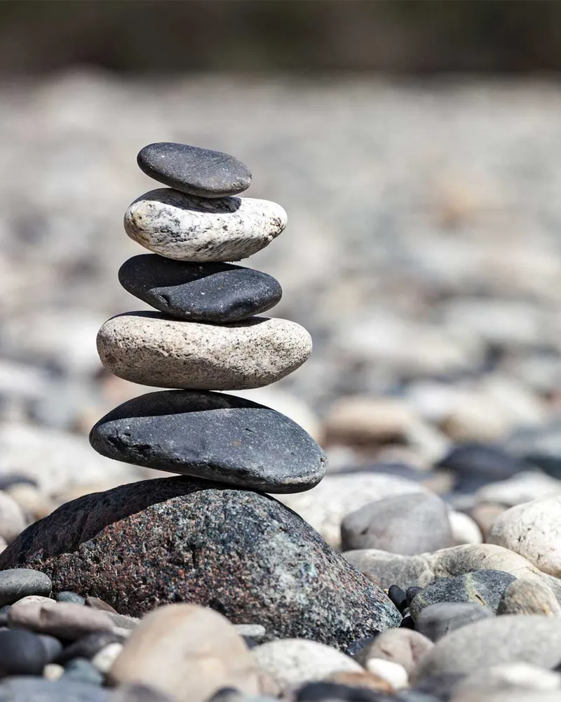 Stones balanced on top of each other on a riverbank