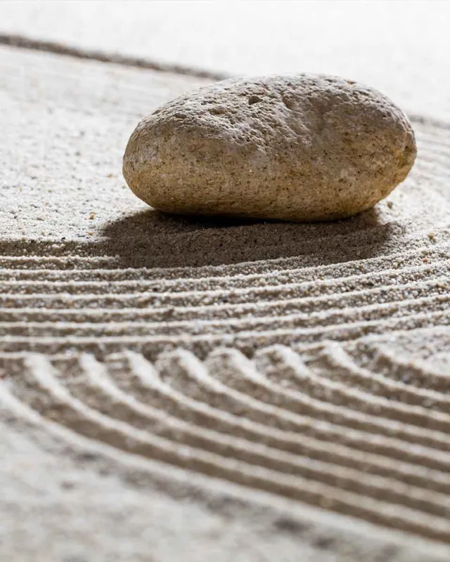 Stein in einem geharkten Zen-Sandgarten